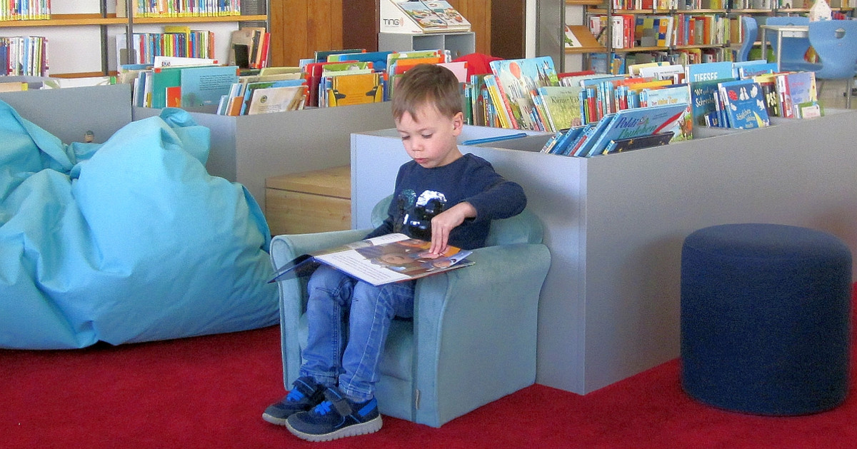 Kleiner Junge in der Stadtteilbibliothek Böckingen in ein Buch vertieft